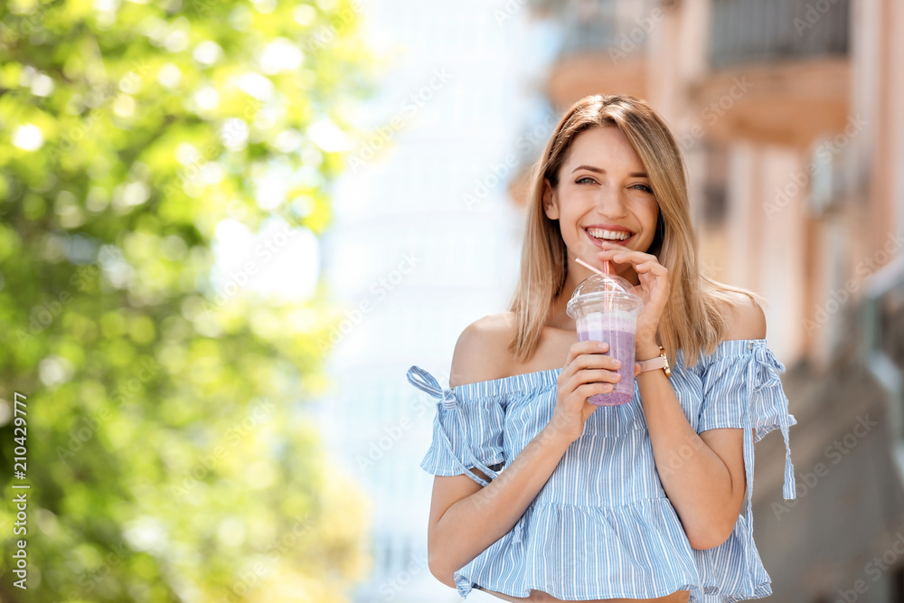 Young woman with plastic cup of healthy smoothie outdoors Young woman with plastic cup of healthy smoothie outdoors