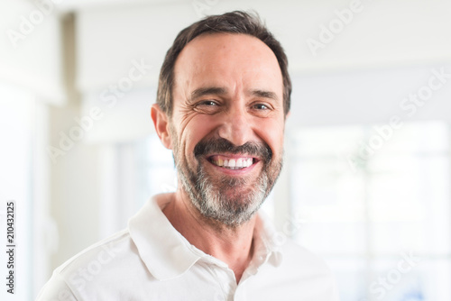 Handsome middle age man with a happy face standing and smiling with a confident smile showing teeth