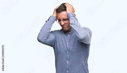 Handsome young elegant man wearing glasses suffering from headache desperate and stressed because pain and migraine. Hands on head.