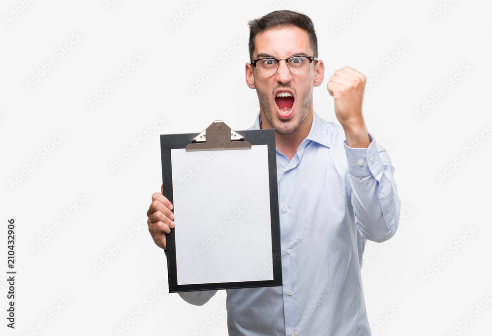 Handsome young business man showing a clipboard annoyed and frustrated shouting with anger, crazy and yelling with raised hand, anger concept Handsome young business man showing a clipboard annoyed and frustrated shouting with anger, crazy and yelling with raised hand, anger concept