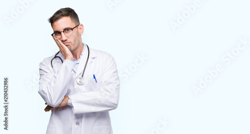 Handsome young doctor man thinking looking tired and bored with depression problems with crossed arms. © Krakenimages.com