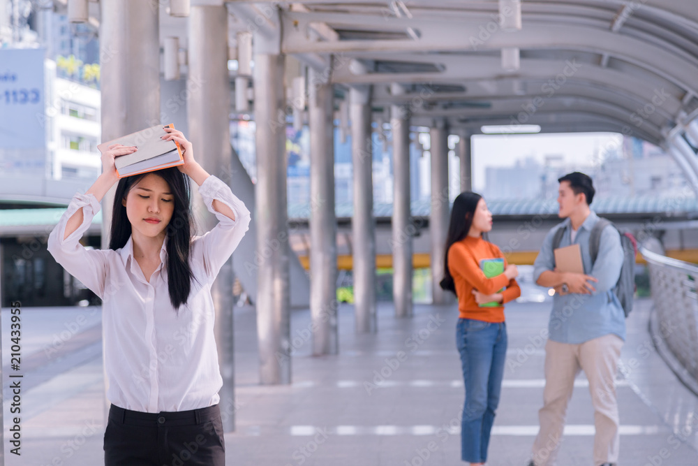 Front view of three asian students walking and talking in an university campus. Front view of three asian students walking and talking in an university campus.