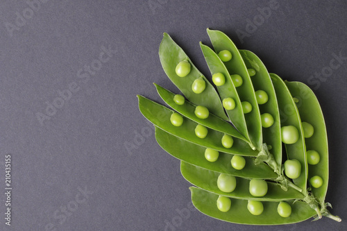 Fresh, green peas in a stunt on a black background