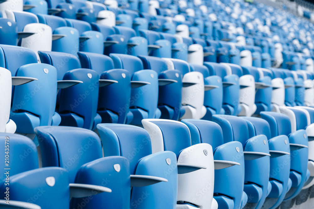 Multi-colored armchairs with numbers on a football stadium. Blue and white color. Multi-colored armchairs with numbers on a football stadium. Blue and white color.