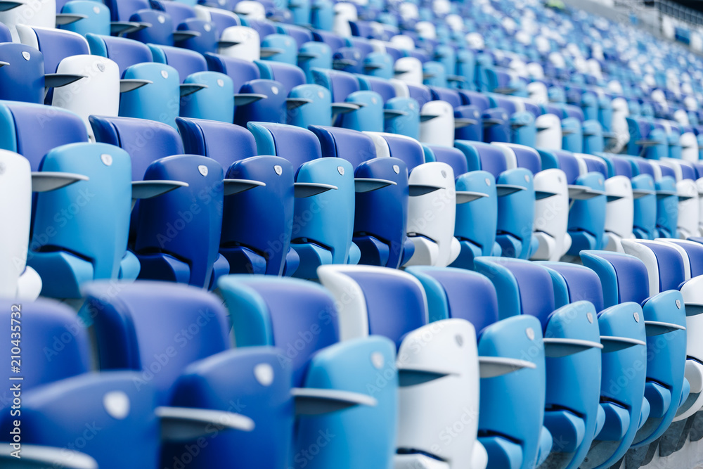 Multi-colored armchairs with numbers on a football stadium. Blue and white color. Multi-colored armchairs with numbers on a football stadium. Blue and white color.
