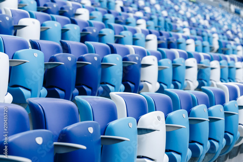 Multi-colored armchairs with numbers on a football stadium. Blue and white color.