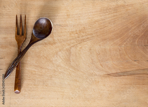 Wooden spoon and fork on wooden background