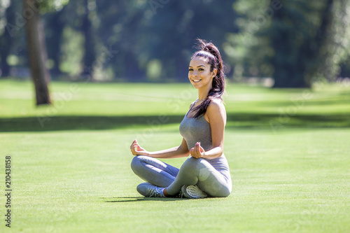 Young beautiful girl doing yoga exercises outdoor