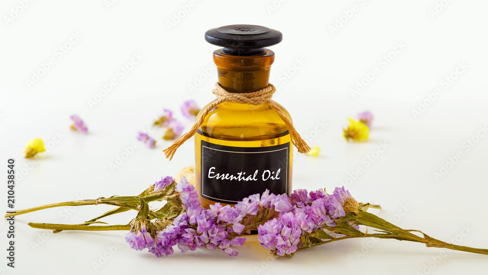 Essential oil with flowers on white - obrazy, fototapety, plakaty 