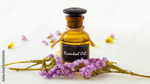 Essential oil with flowers on white