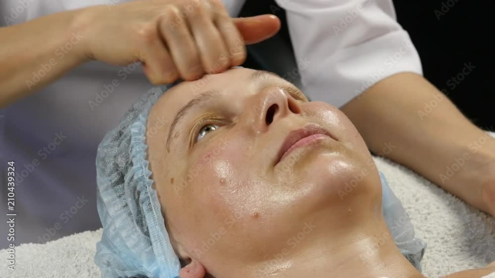 female doctor doing anti-aging massage to client. woman enjoys plastic face massage in spa saton. 4K female doctor doing anti-aging massage to client. woman enjoys plastic face massage in spa saton. 4K