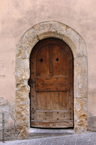 Old door with eroded stone arch in the city Sion, Switzerland © Yü Lan