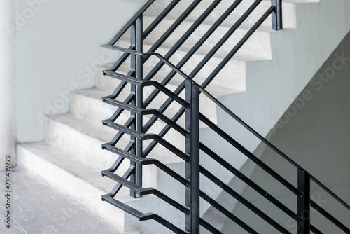 Fototapete Stairway with black metallic banister in a new modern building architecture