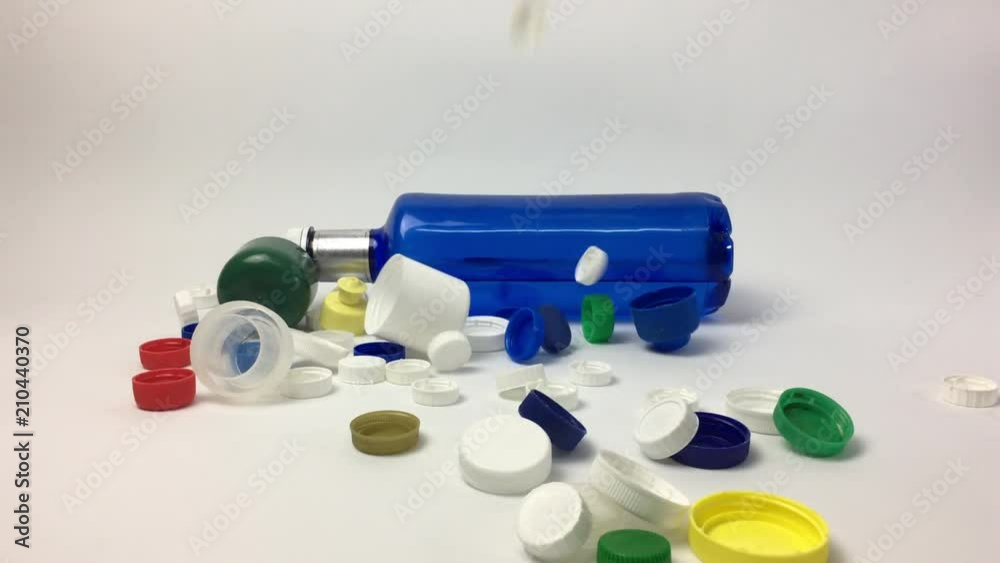 Escena con botella de plastico y tapones cayendo.