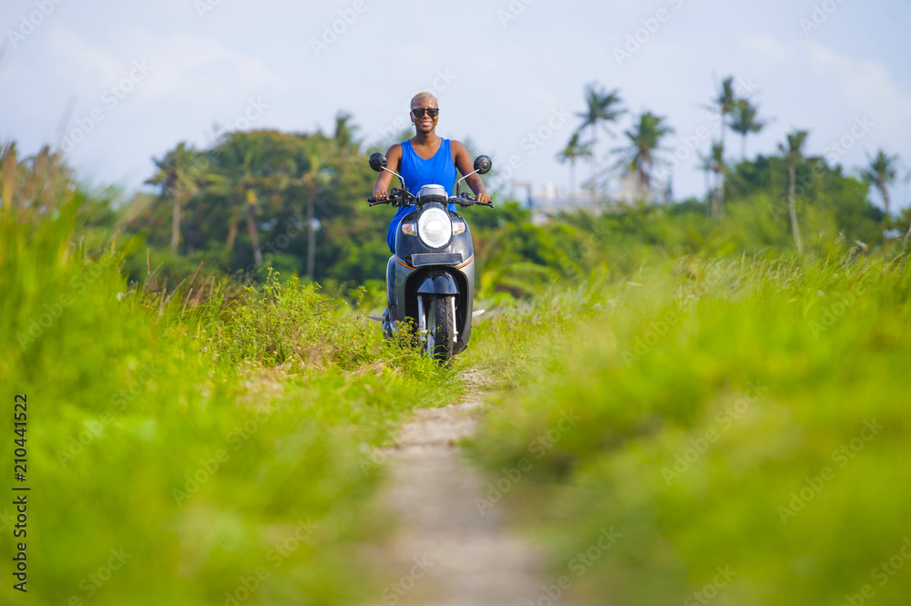 young attractive tourist afro American black woman riding motorbike happy in beautiful Asia countryside along green rice fields smiling free on her scooter young attractive tourist afro American black woman riding motorbike happy in beautiful Asia countryside along green rice fields smiling free on her scooter