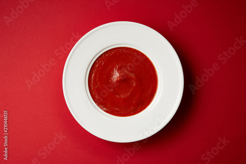 top view of tasty tomato soup in white plate on red table © LIGHTFIELD STUDIOS