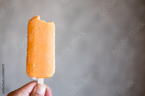 Orange bitten ice pop or popsicle photo