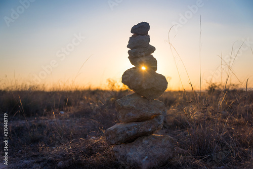 Pyramid of stones in the steppe at sunset