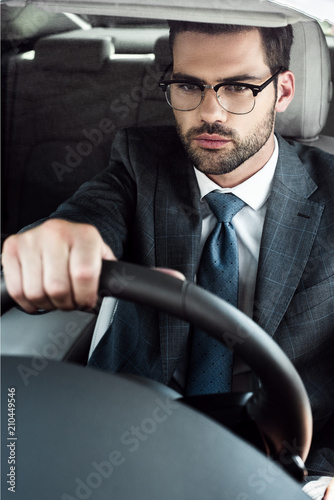 portrait of young businessman in eyeglasses driving car © LIGHTFIELD STUDIOS