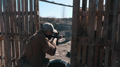 Slow motion footage. Man firing shoots a carbine in training killhouse photo