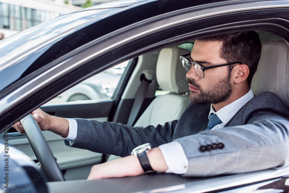side view of businessman in eyeglasses driving car side view of businessman in eyeglasses driving car