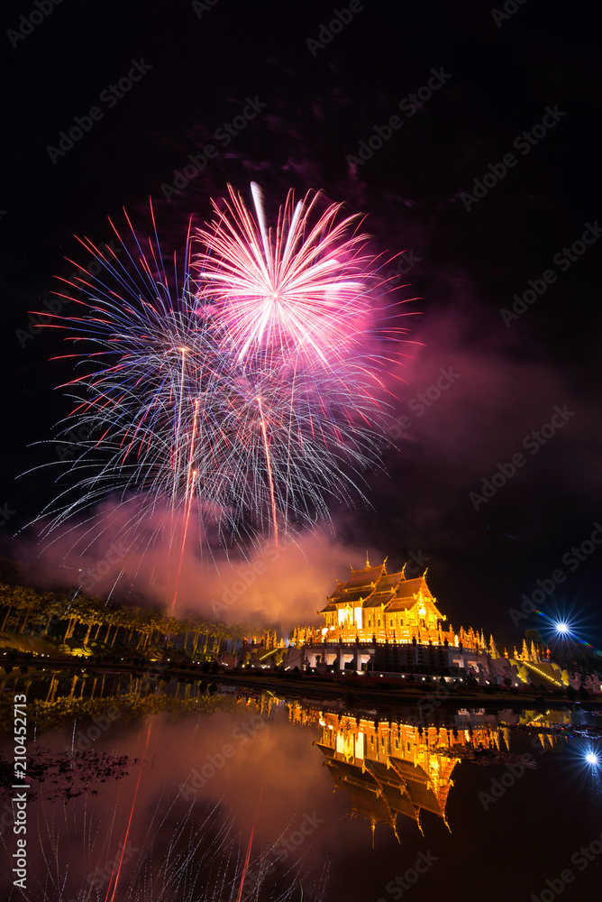 Fototapeta premium Fireworks celebrate the New Year 2018 at Rajapruek Royal Park, Chiang Mai with beutiful light of Hor Khum Luang temple,Thai Tradition Building