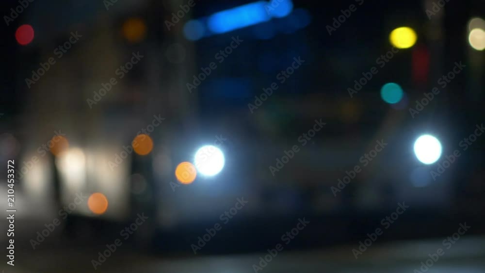 Defocused nighttime shot of a city bus and passing cars