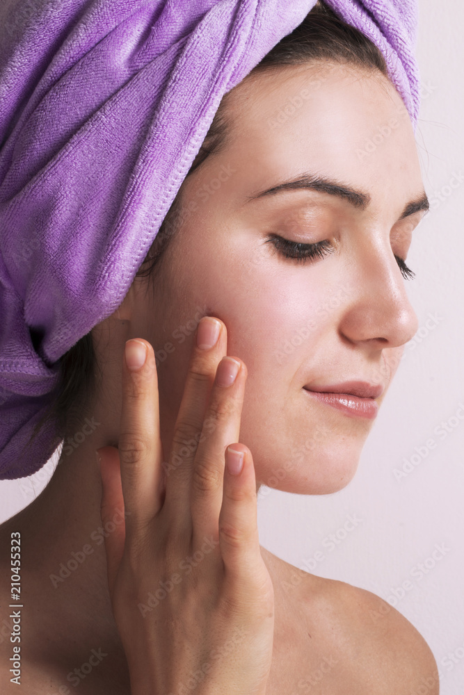 Joven mujer colocando crema facial,masajeando rostro Joven mujer colocando crema facial,masajeando rostro