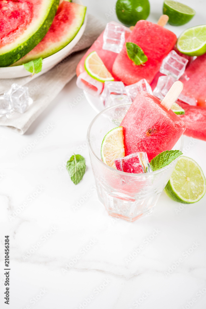 Sweet summer watermelon and lime popsicles with sliced watermelon and mint, on white marble background copy space Sweet summer watermelon and lime popsicles with sliced watermelon and mint, on white marble background copy space
