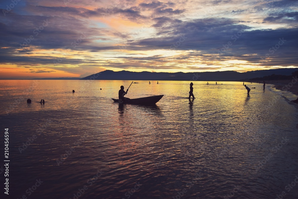 Golden sunset with fishermen at the background at Kande Beach, Lake Malawi, Malawi
