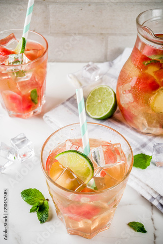 Iced watermelon and lime green tea with mint leaves, marble white background copy space