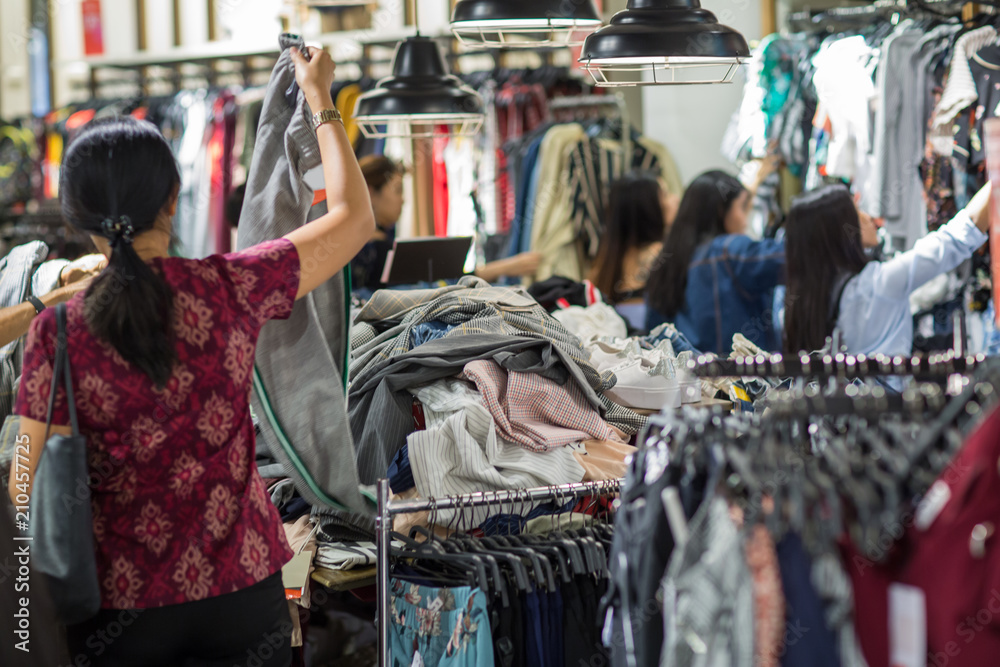 Shopping, seasonal sale in the shop. Pile of clothes on sale in shop