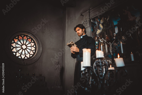 Priest reading and praying in the church