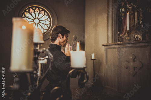 Priest reading and praying in the church photo