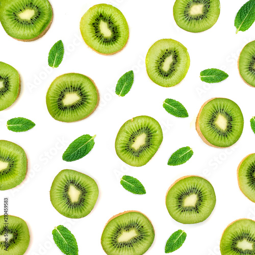 Fruit Pattern - Creative layout made of Kiwi fruits and peppermint leaves. Many slices of ripe Kiwifruit. Flat lay.