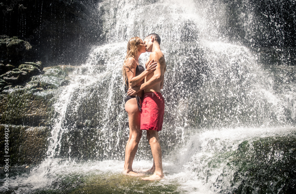 Couple kiss under the waterfall