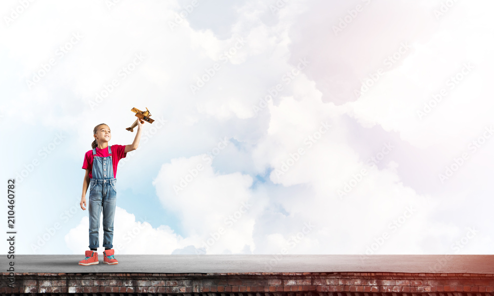 Concept of careless happy childhood with girl dreaming to become pilot Concept of careless happy childhood with girl dreaming to become pilot