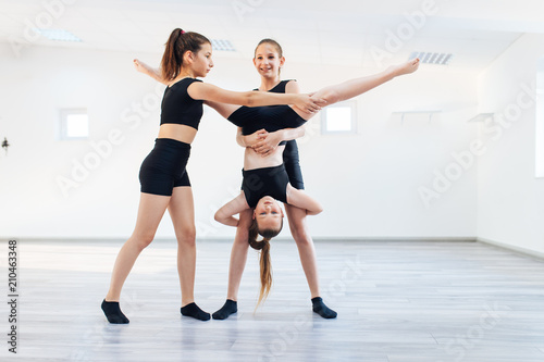 Grupa pięknych nastoletnich dziewcząt uprawiających nowoczesny taniec baletowy.
