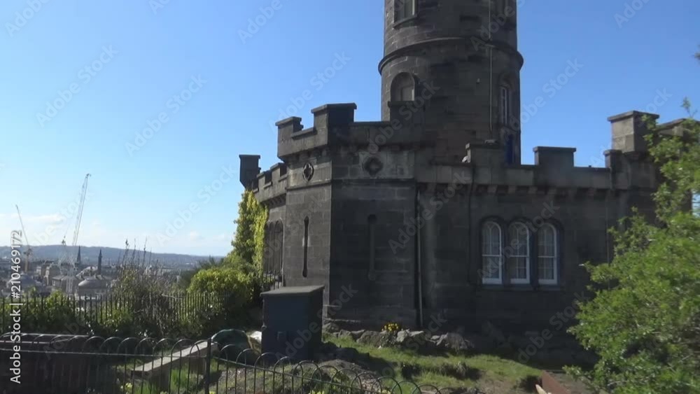 A small part of a watch tower on a hill, grass and bushes, Edinburgh, Scotland A small part of a watch tower on a hill, grass and bushes, Edinburgh, Scotland