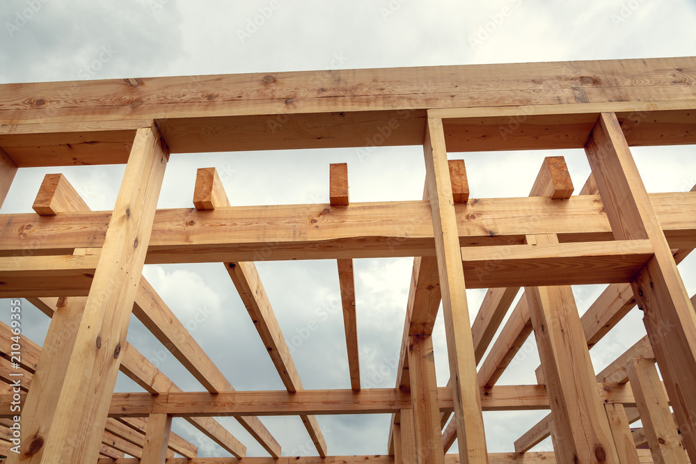 Wooden construction of an unfinished house. Skeleton of a building made of beams. Wooden construction of an unfinished house. Skeleton of a building made of beams.