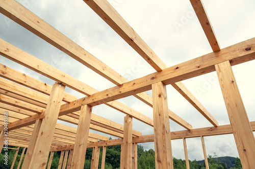 Wooden construction of an unfinished house. Skeleton of a building made of beams.