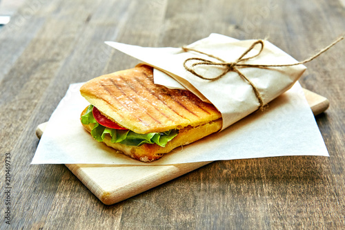 sandwich in an envelope, tied with rope to a wooden table photo