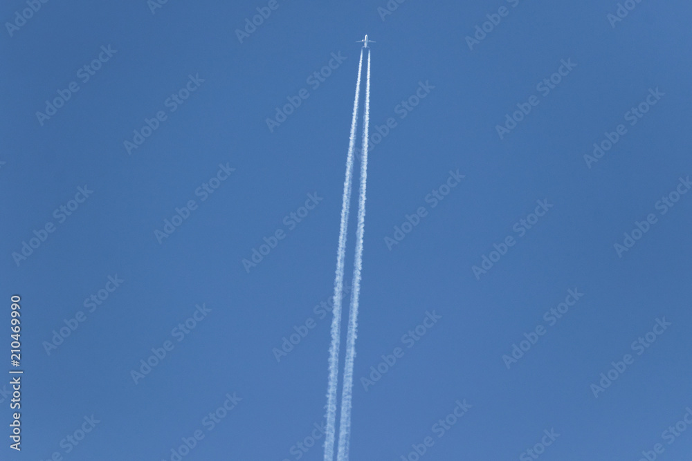 One plane leaves contrails trace in a clear blue sky. Airplane vapour trails. One plane leaves contrails trace in a clear blue sky. Airplane vapour trails.