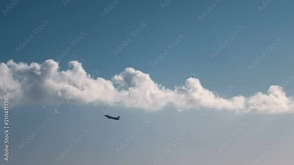 silhouette of an airplane gaining height against a blue sky and clouds silhouette of an airplane gaining height against a blue sky and clouds