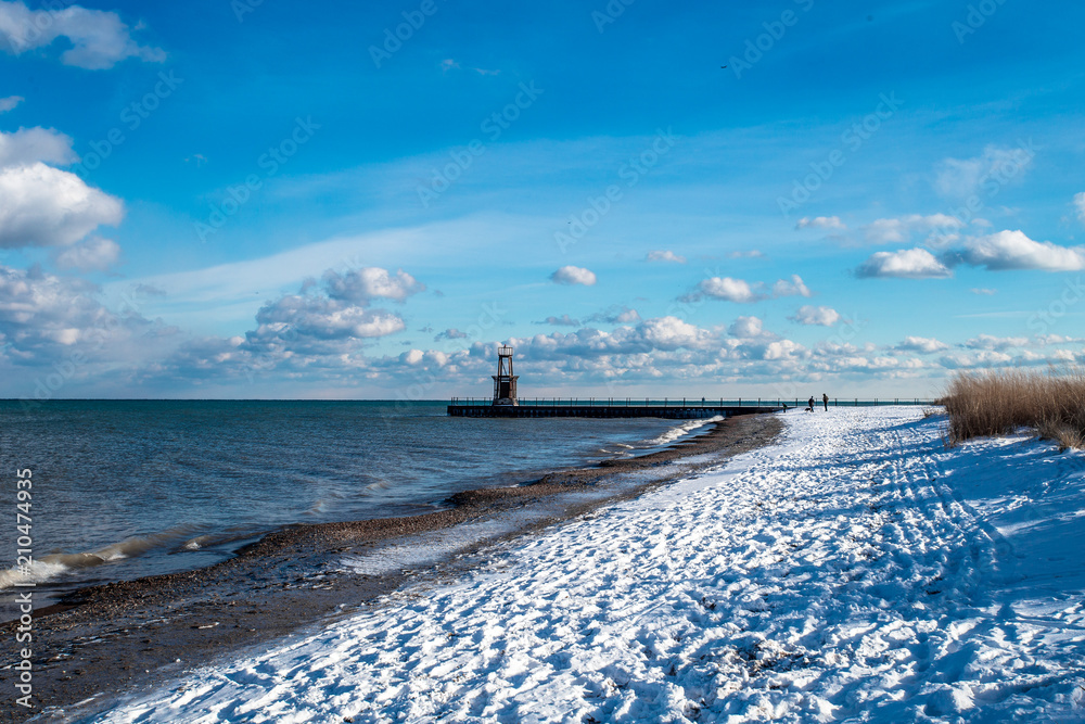 Snow covered beach with pier
