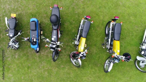 Aerial top down view slow and steady flight over classic mopeds are small motorcycles generally having less stringent licensing requirement than motorcycles colorful machines beautiful 4k quality photo