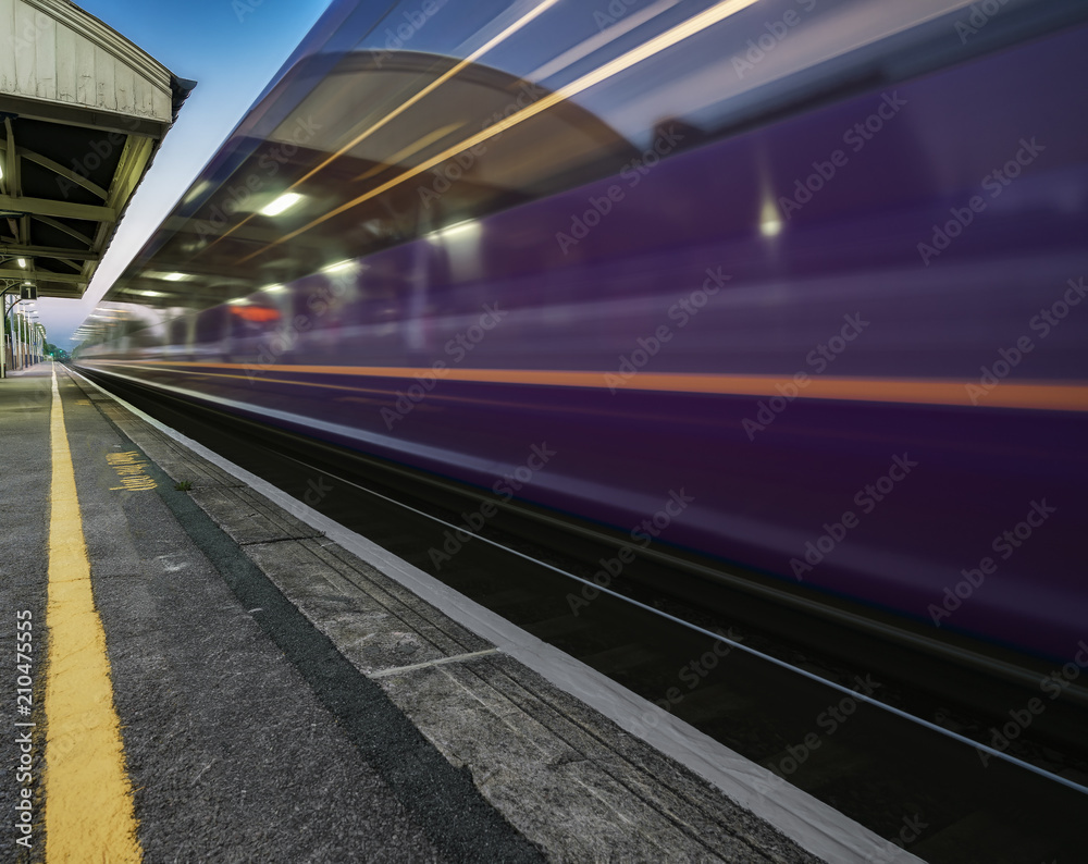 Obraz premium Pociąg pędzący przez stację w Wielkiej Brytanii