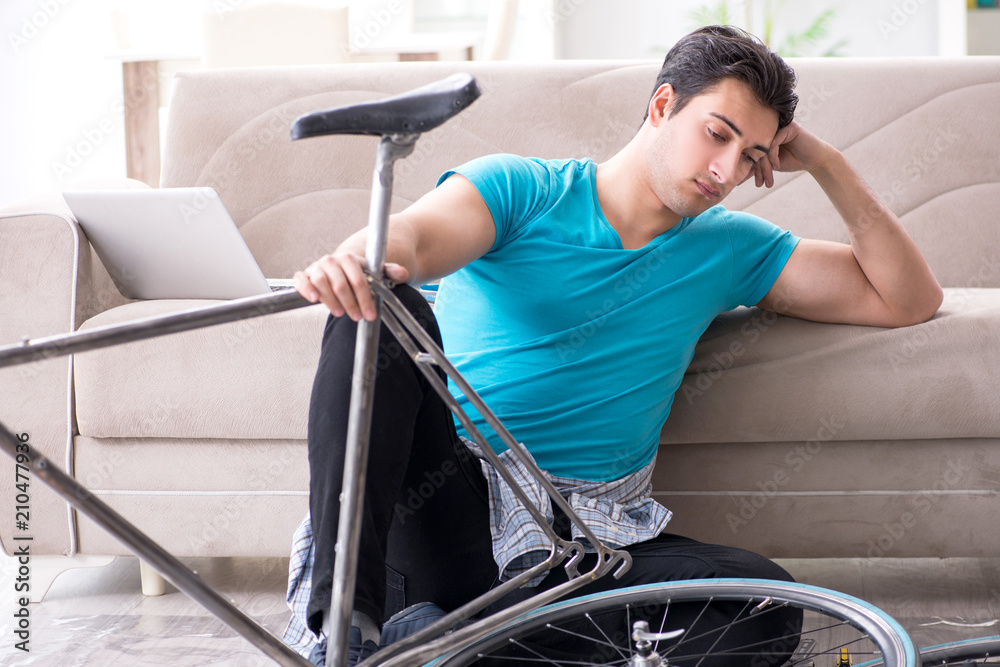 Young man repairing bicycle at home