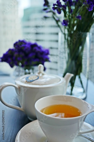 A colorful and delicious set of afternoon tea party in lavender theme  close up of teapot with skyscraper background.