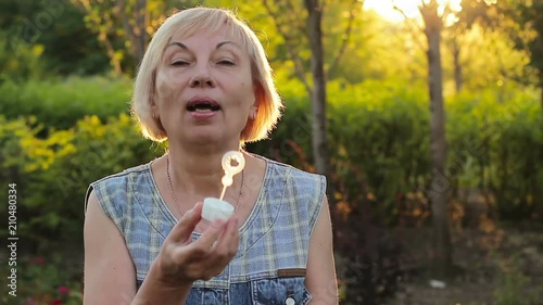 Emotional elderly woman blowing bubbles photo